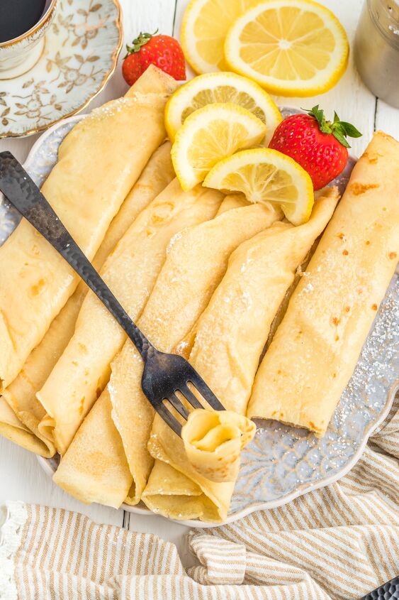 parisian crepes will make you the star of brunch, Rolled crepes on a plate with strawberries and lemon