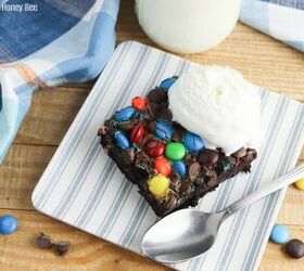 chocolate dump cake recipe with cake mix pudding mix and m ms, A serving of chocolate dump cake sitting on a blue and white striped plastic plate with a scoop of vanilla ice cream on top