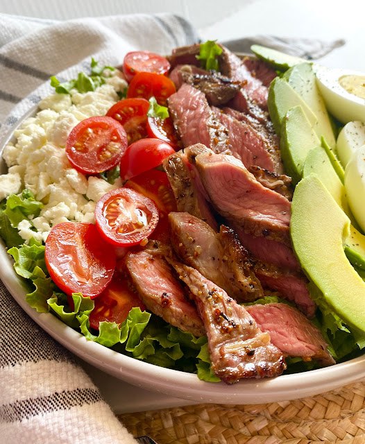 steak cobb salad, Close up of steak cobb salad in a grey bowl on a placement