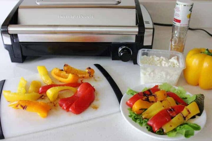 grilled peppers with feta cheese, colorful peppers cut in half in front of a grill