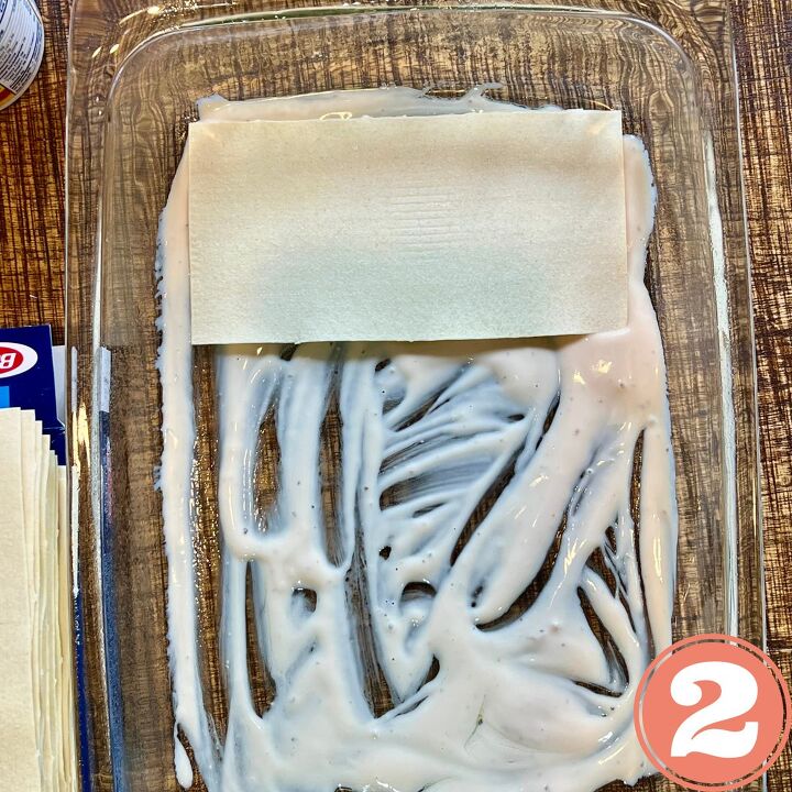 easy meatless white spinach lasagna, no bake lasagna noodle in a glass tray with Alfredo sauce