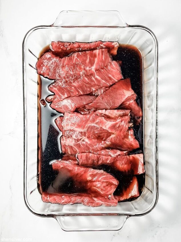 make this easy beef scallion negimaki recipe tonight, flank steak in marinade in a pyrex dish