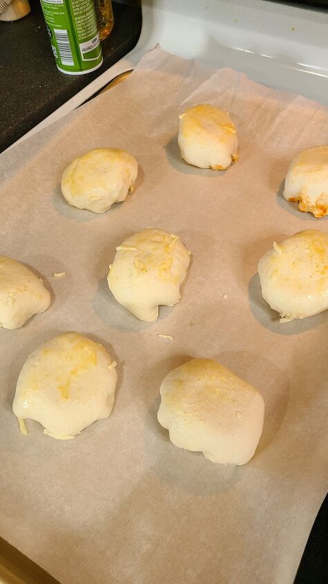 cheesy pizza meatball bombs recipe, A baking sheet lined with parchment paper and topped with unbaked meatball bombs
