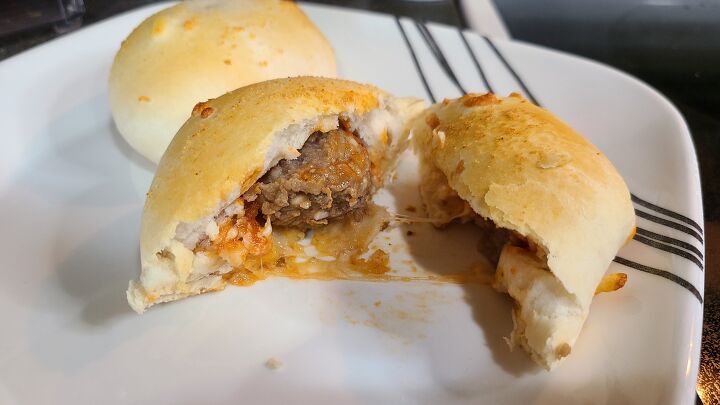 cheesy pizza meatball bombs recipe, A meatball bomb on a plate cut in half