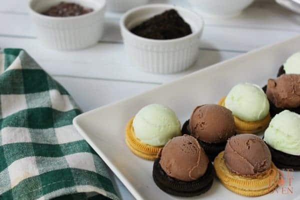 chocolate covered ice cream bites with oreos, Oreo cookies with chocolate and mint ice cream scoops on top