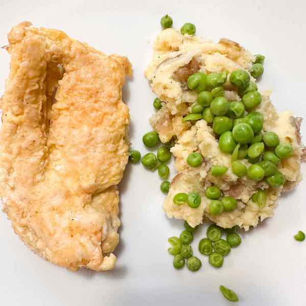 best smashed potatoes with horseradish recipe, chicken with smashed potatoes and horseradish garnished with peas