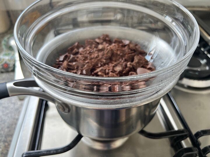 best brazilian cake bolo de brigadeiro, Chocolate pieces in a clear glass bowl sitting on a smaller pot of water on the stove for Brigadeiro Brazilian Cake