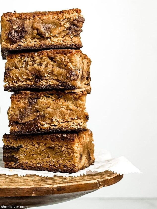 the best miso brown butter chocolate chunk blondies, miso brown butter chocolate chunk blondies on a wooden cake stand