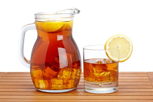 herbal infused iced tea, glass pitcher filled with iced tea lemon slices