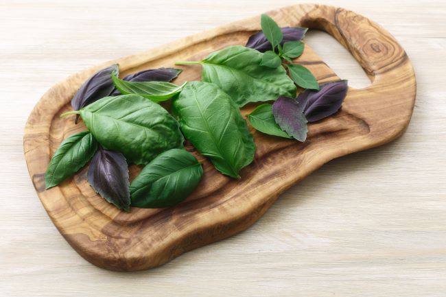 herbal infused iced tea, wooden cutting board with basil leaves