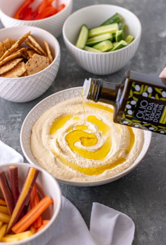 the best classic homemade hummus, A bowl of hummus being drizzled with extra virgin olive oil