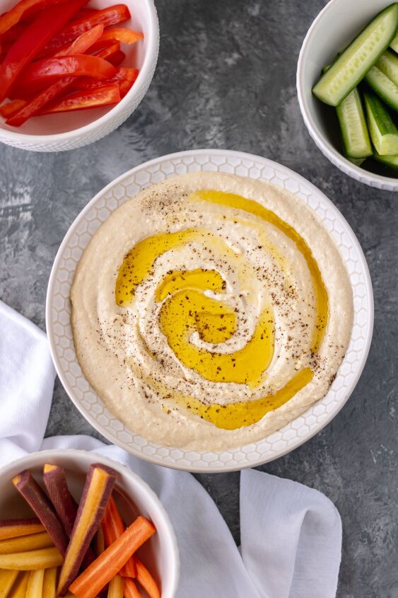 the best classic homemade hummus, A bowl of homemade hummus covered with extra virgin olive oil and black pepper