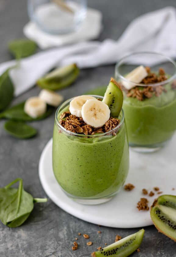 kiwi avocado green smoothie, Two glasses of a Kiwi Avocado Green Smoothie topped with granola a kiwi wedge and banana slices