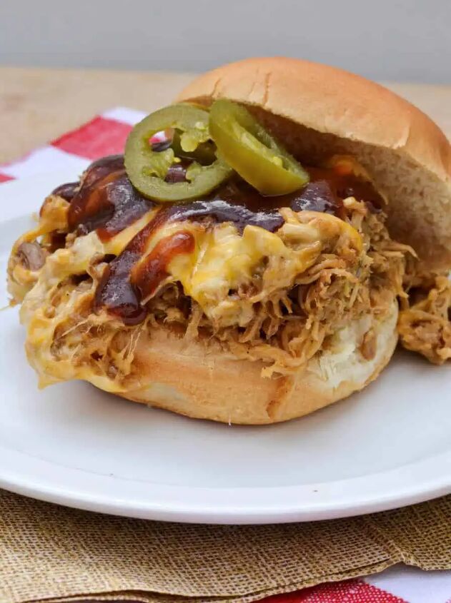 bbq pork in the oven, Pulled Pork Sandwich Topped With Cheddar Cheese Jalapenos and BBQ Sauce