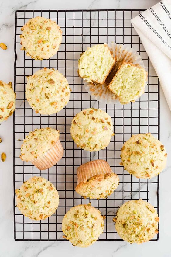 pistachio pudding muffins, Muffins on a black wire rack with one open faced in the top right corner