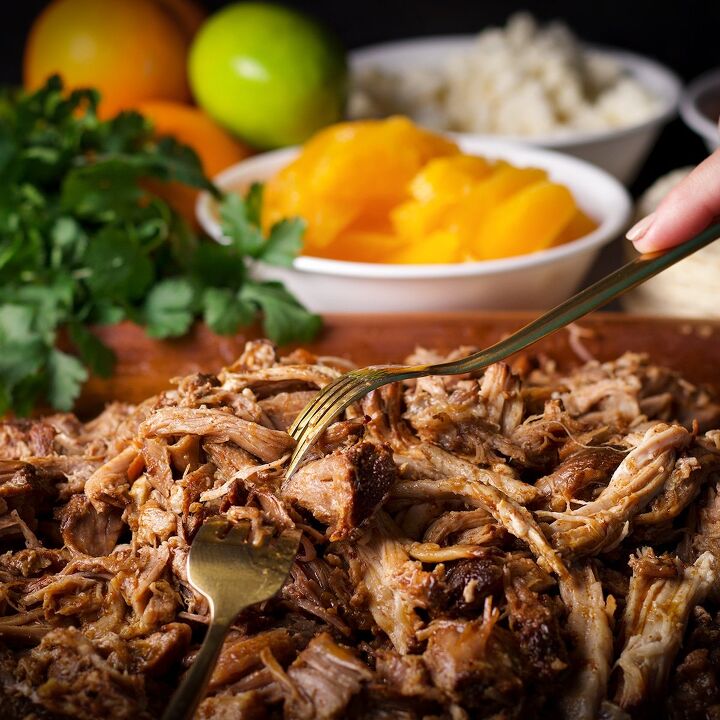 camping tacos shredded pork with pico de gallo, Someone using two forks to shred a cooked pork roast for tacos