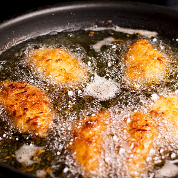 crispy coconut lime chicken, Frying pieces of crispy coconut lime chicken in hot oil
