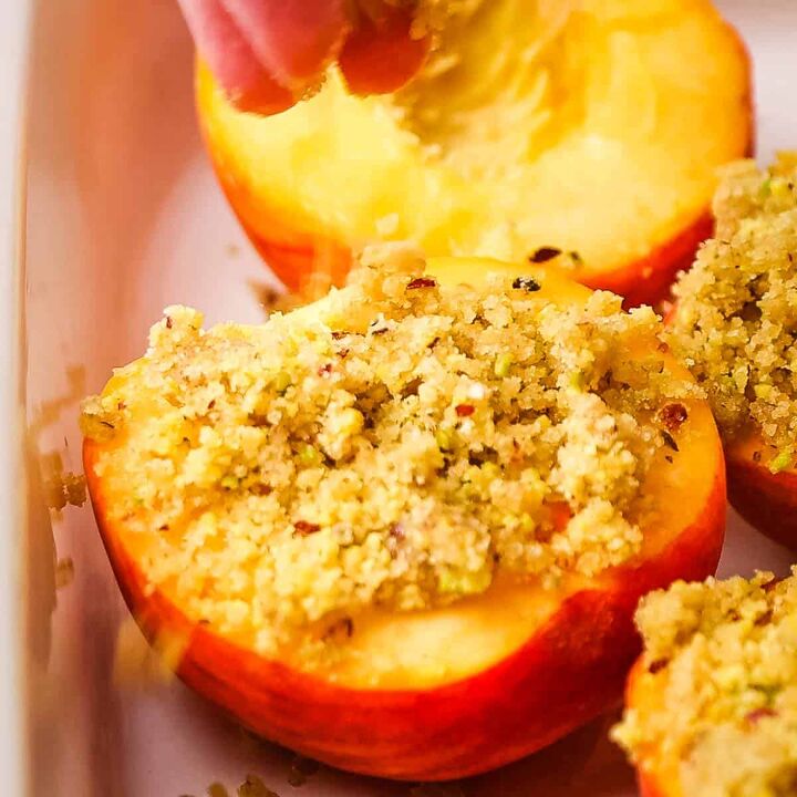 roasted peaches with pistachio crumble, Peach halves in a baking dish topped with pistachio crumble