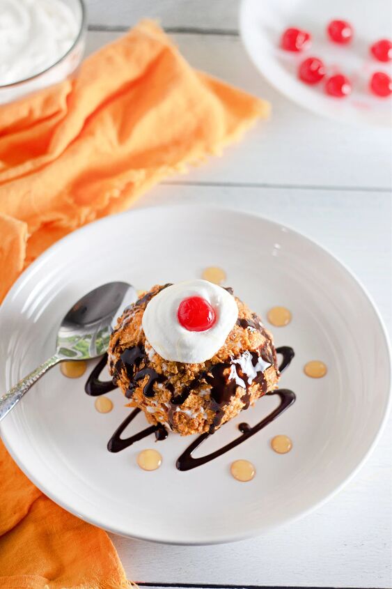 how to make crispy homemade fried ice cream, Fried ice cream on a plate with cherries chocolate syrup and caramel sauce