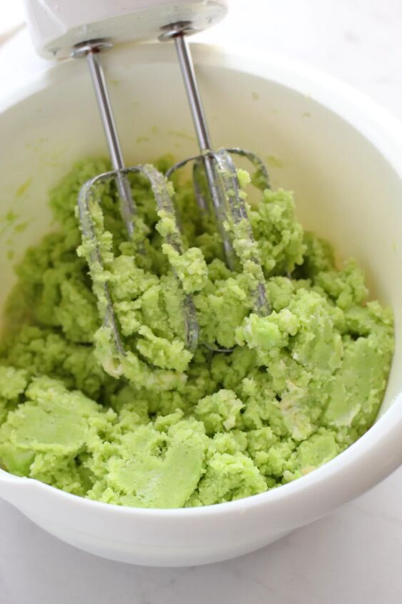 Green cake mix in a bowl with a mixer
