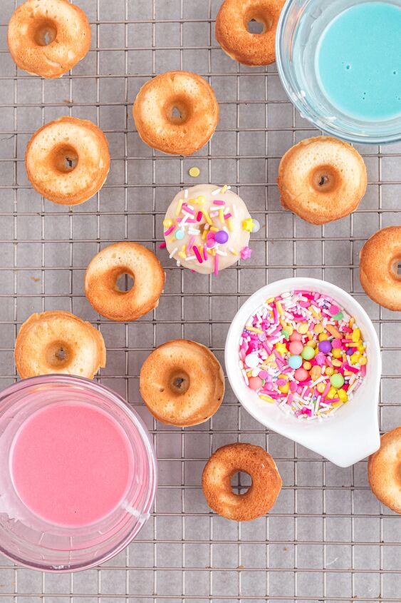 bright and delicious mini donuts with colorful glaze little fairy do, Baked donuts on a rack being decorated with sprinkles
