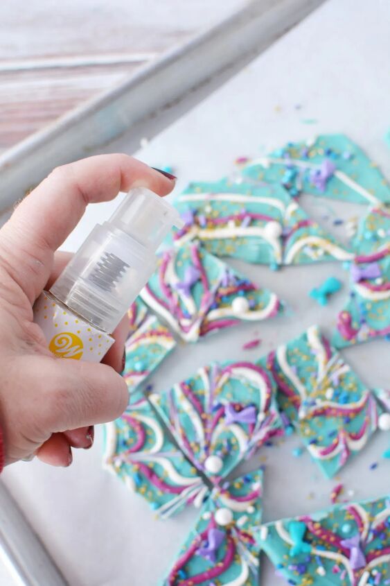 sparkly mermaid bark candy for an easy under the sea sweet, Spraying edible gold glitter onto mermaid candy