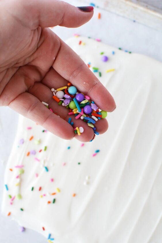funfetti frenzy how to make delicious funfetti bark candy, Sprinkling sprinkles onto melted almond bark