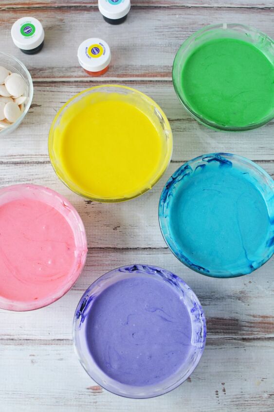 how to make a rainbow trifle dessert for a magical party, Pink yellow green blue and purple colored cake batter in bowls