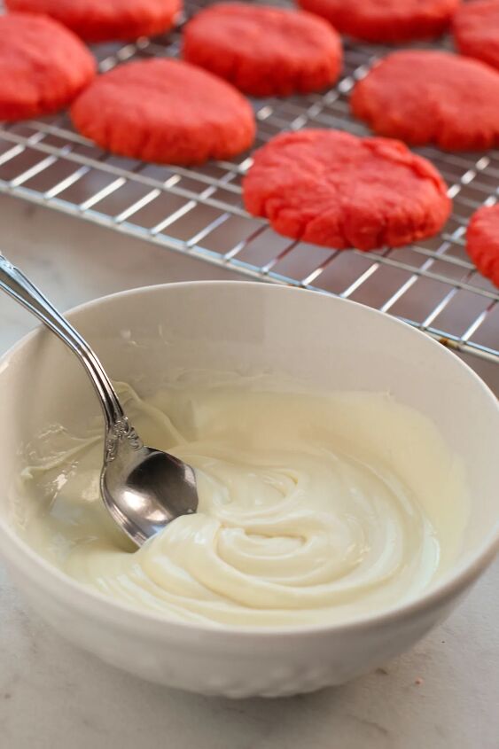 easy and chewy strawberry cake mix cookies recipe, Melted white chocolate in a bowl next to baked strawberry cookies