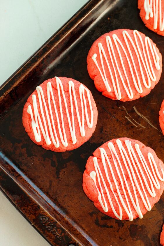 easy and chewy strawberry cake mix cookies recipe, White chocolate drizzle over strawberry cookies on a baking pan