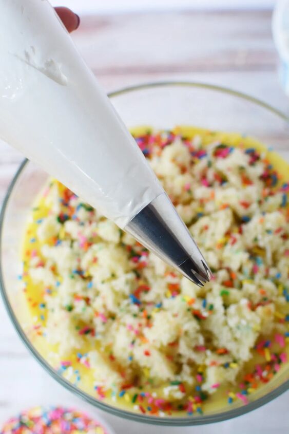 colorful funfetti birthday cake trifle recipe, Whipped topping in a piping bag above a trifle