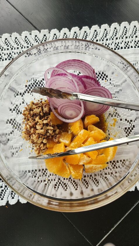 scallop salad recipe with orange honey walnut vinaigrette, glass mixing bowl with orange segments walnuts and red onion slices