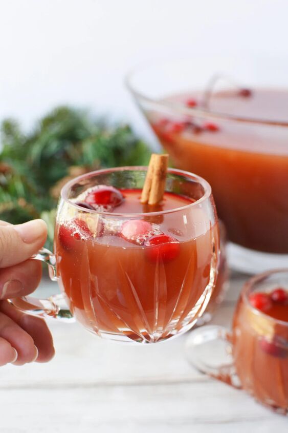 cranberry and cinnamon christmas punch recipe, Holding a glass of Christmas punch