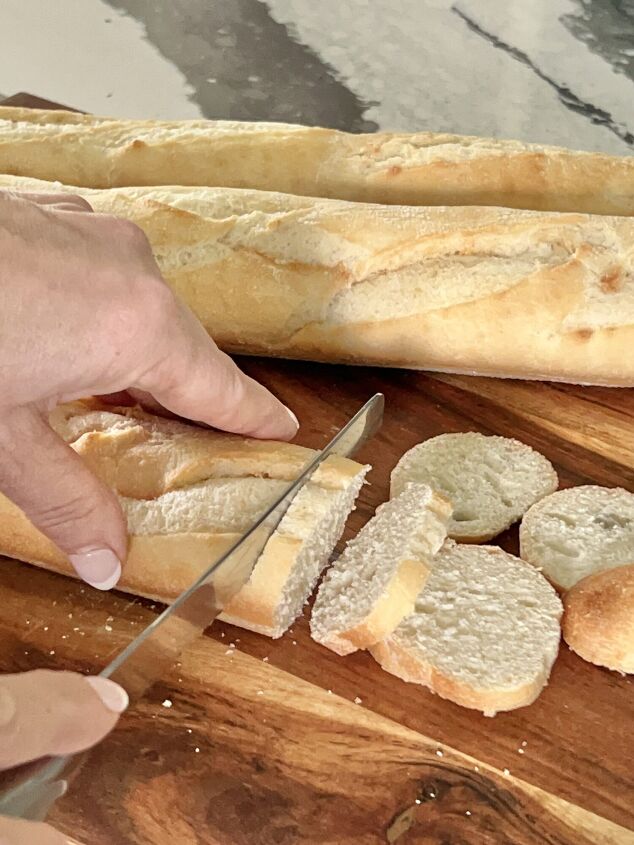 a simple and easy bruschetta baguette appetizer recipe, Slicing the baguette bread into thin slices with a serrated knife