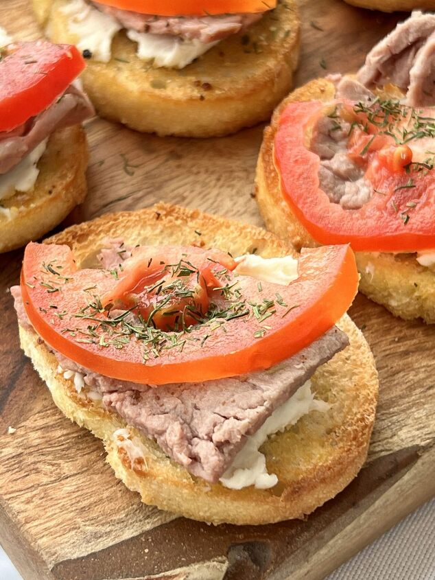 a simple and easy bruschetta baguette appetizer recipe, Tomato slices and dill weed are added to the top of the bruschetta appetizer