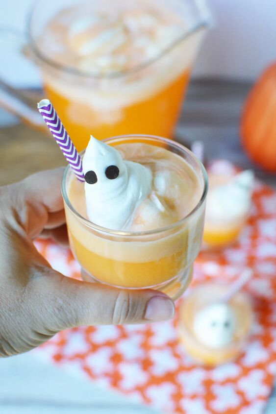 spooky ghost punch, Holding a cup of orange ice cream punch with a ghost topping