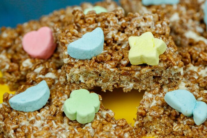 chocolate rice krispies treats, a stack of chocolate rice krispies with lucky charm marshmallows on a yellow cake stand
