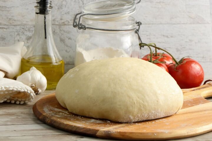 bread machine thin crust pizza dough recipe, a ball of pizza dough on a cutting board