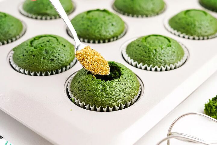 stuffed green velvet cupcakes, Spooning in gold sprinkles into green cupcakes for the filling