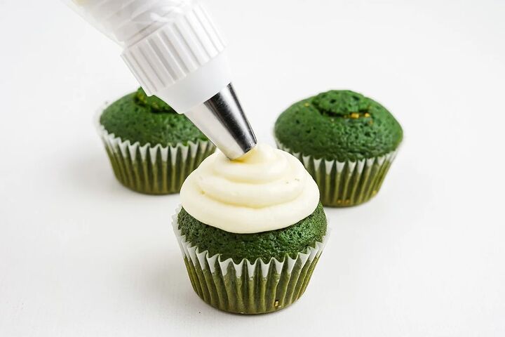 stuffed green velvet cupcakes, Piping white frosting onto green cupcakes