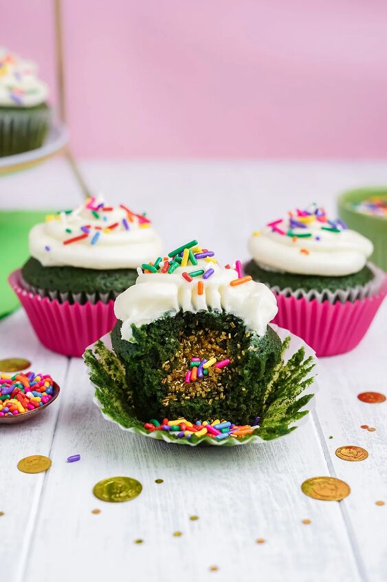stuffed green velvet cupcakes, Three cupcakes with one unwrapped and gold sprinkles as filling falling out