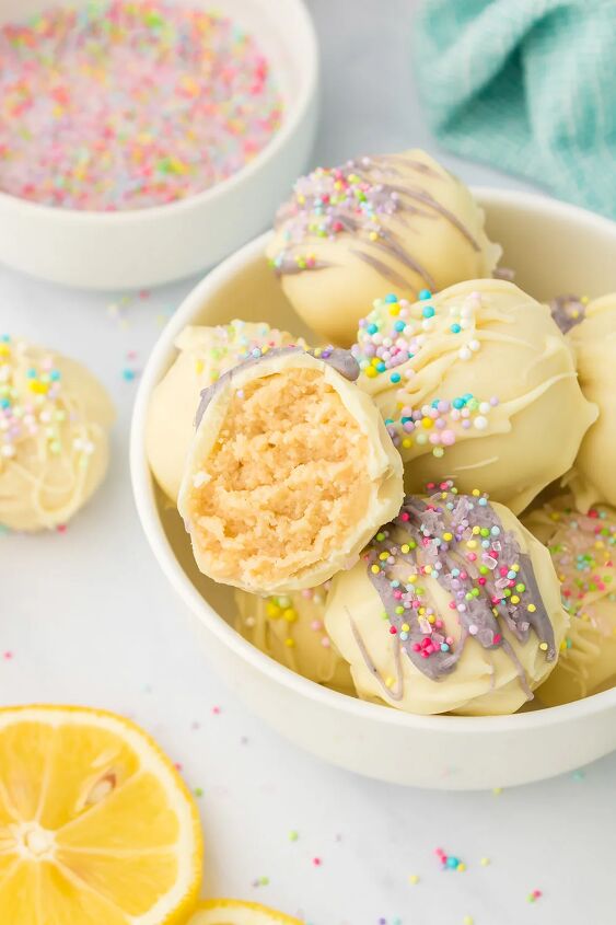 light and creamy lemon oreo truffles, Lemon candy truffles in a bowl with one missing a bite