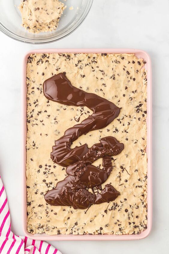 cookie dough bark, Pouring melted chocolate on top of cookie dough in a baking sheet