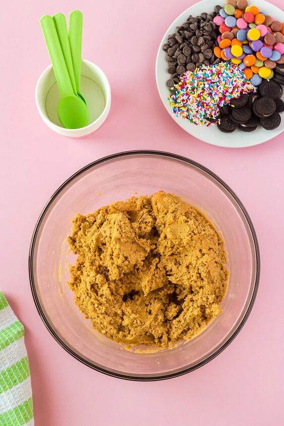 edible monster cookie dough, Cookie dough in a bowl green spoons and other candies in a bowl