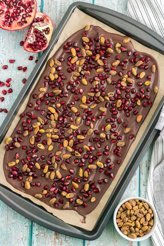 chocolate pomegranate bark with pistachios, Chocolate bark in a baking sheet topped with pomegranate arils and pistachio nuts
