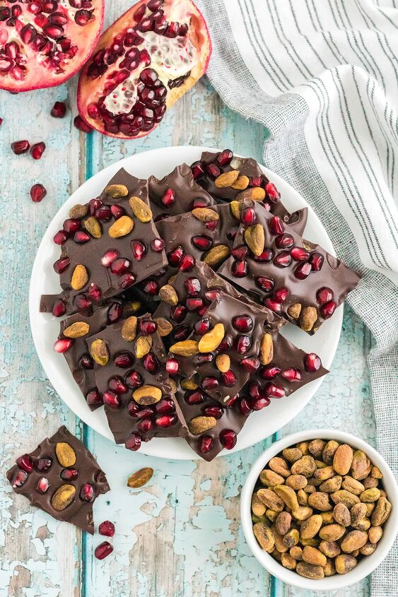 chocolate pomegranate bark with pistachios, Bark candy on a plate next to pistachios and pomegranates