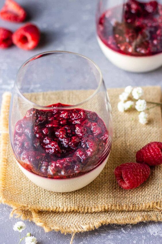 easy vegan raspberry panna cotta without gelatin, Vegan raspberry panna cotta in glasses on dark blue background with white flowers on a side