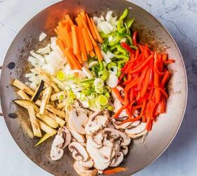 vegan stir fry noodles ready in under 30 minutes, Adding sliced vegetables to a wok pan