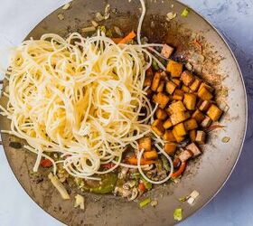 vegan stir fry noodles ready in under 30 minutes, Adding cooked noodles and tofu to a wok with cooked veggies