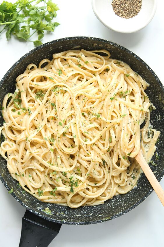 creamy white wine pasta sauce, A frying pan on a white background with linguine pasta tossed in the sauce